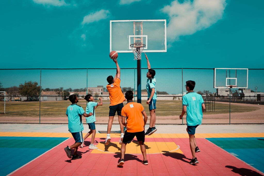 Energetic scene of teenagers playing basketball on a colorful outdoor court.